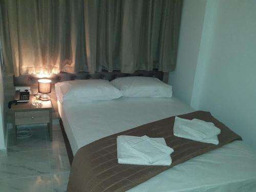 two beds in a hotel room with towels on them at Hotel Rex in Thessaloniki