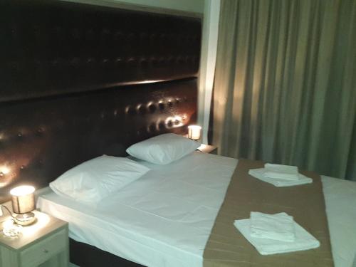 a bed with two white pillows and a wooden headboard at Hotel Rex in Thessaloniki