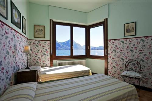 a bedroom with a bed and a large window at Villa Camelia in Verbania
