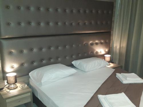 a bedroom with a large bed with a padded headboard at Hotel Rex in Thessaloniki