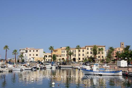 un grupo de barcos atracados en un puerto deportivo con edificios en Villa Riviera, en Portoscuso