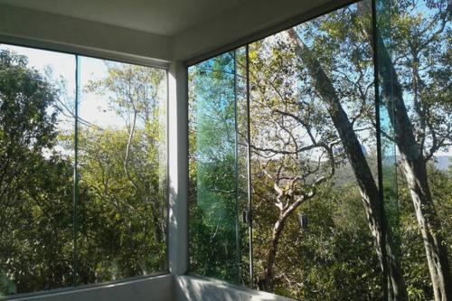 a room with two large windows with trees at Morada dos Elfos in Vale do Capao