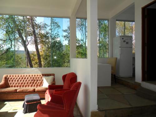 a living room with red chairs and a couch at Morada dos Elfos in Vale do Capao