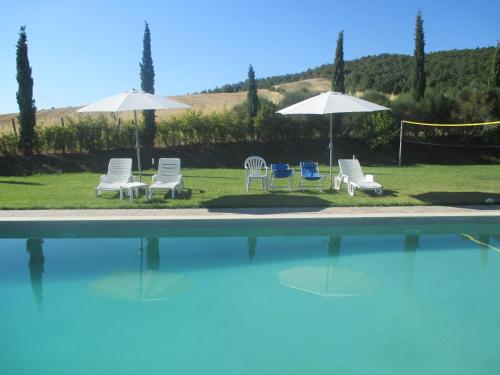 a group of chairs and umbrellas next to a swimming pool at Agriturismo Stigliano in Sarteano