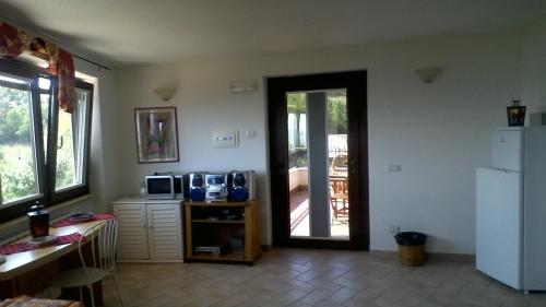 a room with a kitchen with a refrigerator and a door at Cominium Benessere in Alvito