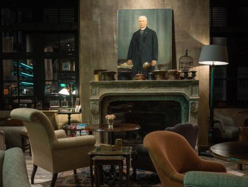 a living room with a painting of a man over a fireplace at 1898 The Post in Ghent