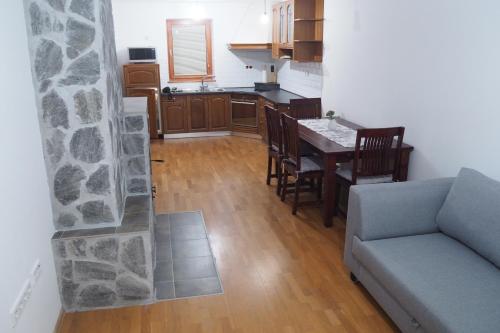 ein Wohnzimmer mit einem Sofa und einem Tisch sowie eine Küche in der Unterkunft Apartment Ajda in Bovec
