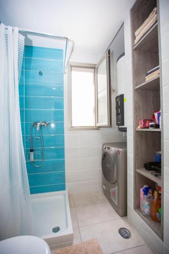 a bathroom with a shower with a blue wall at Altos del Mediterraneo La Zenia in Los Dolses