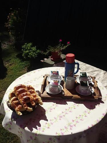 un tavolo con un servizio da tè e un piatto di cibo di Cabana Alpinas del Parque a General Belgrano