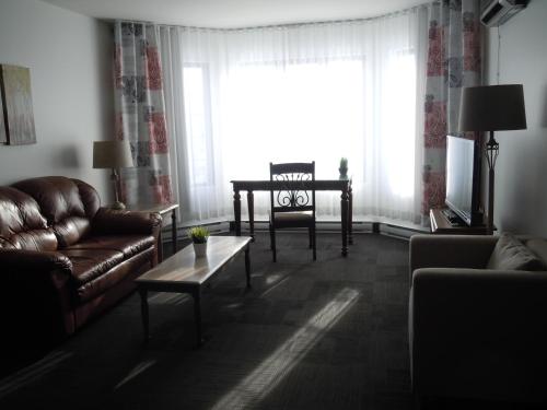 a living room with a couch and a table at L'Auberge Du Lac St-Pierre in Trois-Rivières