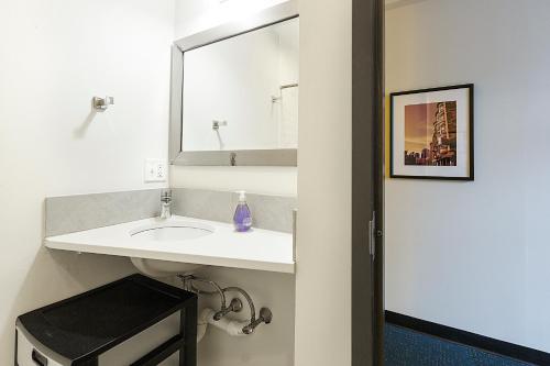 a bathroom with a white sink and a mirror at Temple Place Suites in Boston