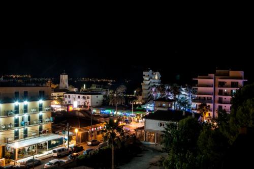 a city lit up at night with cars and buildings at Hostal Alce in Playa de Palma