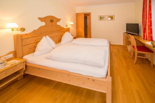 a bedroom with a large bed with white sheets at Haus Jäger in Filzmoos