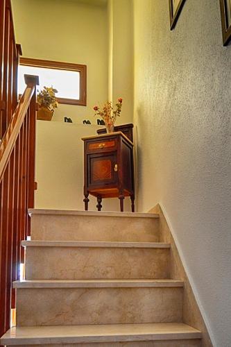 a stairway with a vase of flowers on a table at La Vieja Parra in La Puerta de Segura