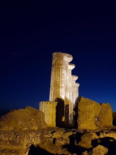 a tall stone tower on top of a mountain at Cala Arenella in Sciacca