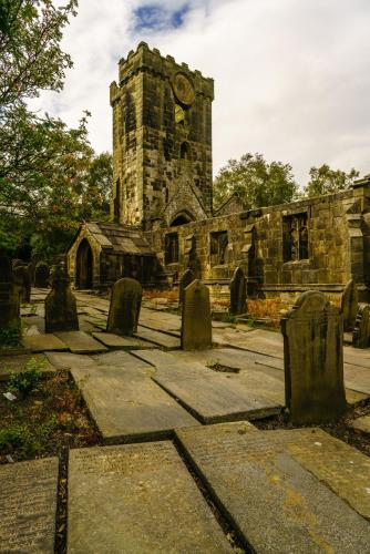 an old stone church with a clock tower at The Cross Inn in Hebden Bridge