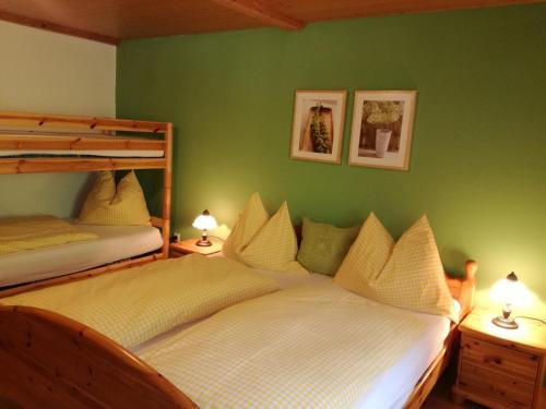 2 Etagenbetten in einem Schlafzimmer mit grünen Wänden in der Unterkunft Apartment Knablhof in Sankt Martin am Tennengebirge