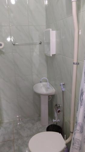 a bathroom with a toilet and a sink at Pousada Moporã, a antiga pousada do Waldir, com amplas suítes no centro de Aiuruoca in Aiuruoca