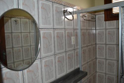 a bathroom with a mirror on a tiled wall at Casa de 4 quartos á 6Km da praia de Lagoinha-ce in Camboa