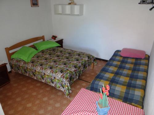 a small bedroom with a bed and a table at Pousada Manu in Canela