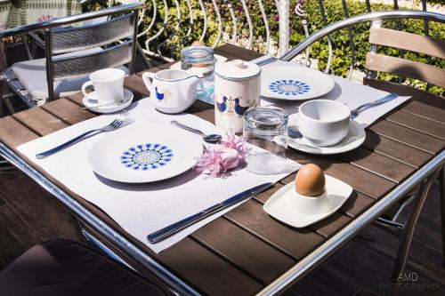 una mesa con platos y tazas y un huevo en ella en Los Flamingos, en La Maddalena