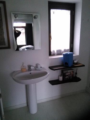 a bathroom with a sink and a mirror and a window at La Meridiana, monolocale in cascina ristrutturata in Boves