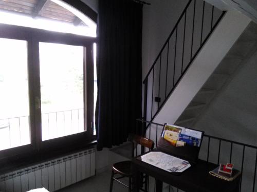 a room with a table and a window and a staircase at La Meridiana, monolocale in cascina ristrutturata in Boves