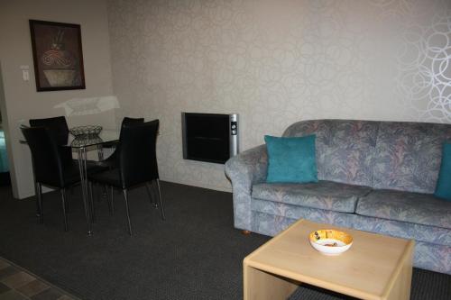 a living room with a couch and a table at Ashbury Park Motel in Timaru