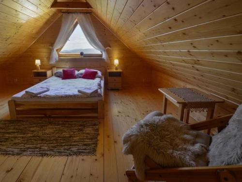 a bedroom in a log cabin with a bed and a window at Domek drewniany simonka zawoja in Zawoja