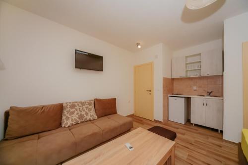 a living room with a couch and a kitchen at Apartments Sole Mar in Sutomore