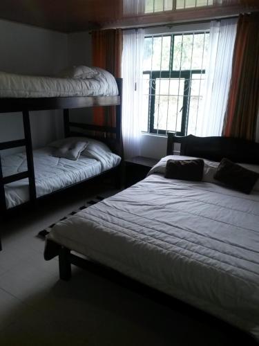 a bedroom with two bunk beds and a window at Hospedaje El Mirador in Iza