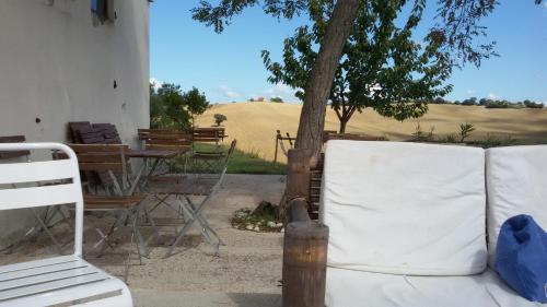 a porch with a couch and a table and a tree at Tenuta Tredici Ulivi in Senigallia