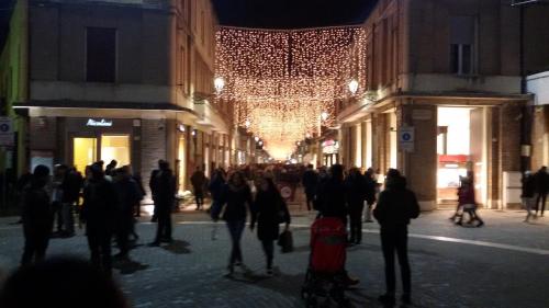 a crowd of people walking down a city street at night at Tenuta Tredici Ulivi in Senigallia