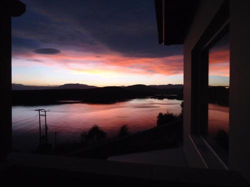 a view of a sunset from a window at Lefka's Villas in Vivari