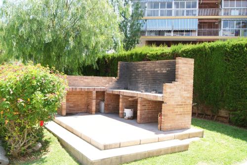 un muro de retención de ladrillos con un banco en un patio en Costa Blanca Apartment en Alicante