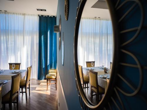 a dining room with tables and chairs and a mirror at Hotel Select in Atessa