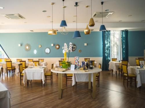 a dining room with tables and chairs and blue walls at Hotel Select in Atessa