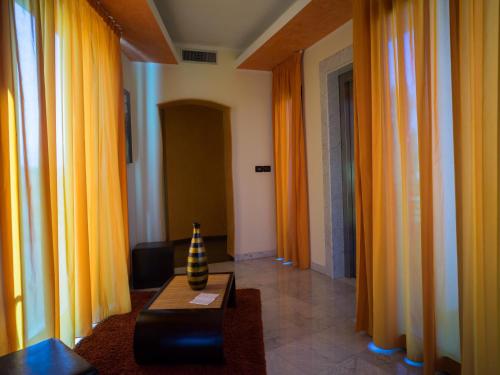 a living room with orange curtains and a vase on a table at Hotel Select in Atessa