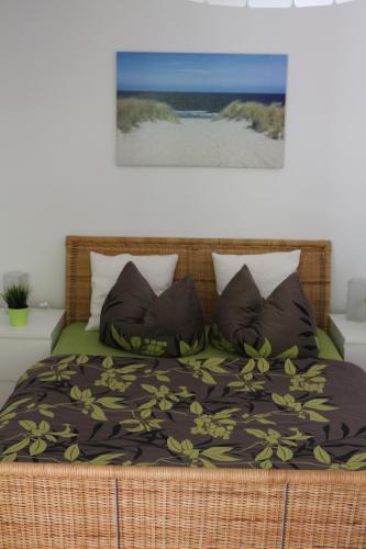 een slaapkamer met een bed met een deken en kussens bij Ferienwohnung Nienhagen in Ostseebad Nienhagen