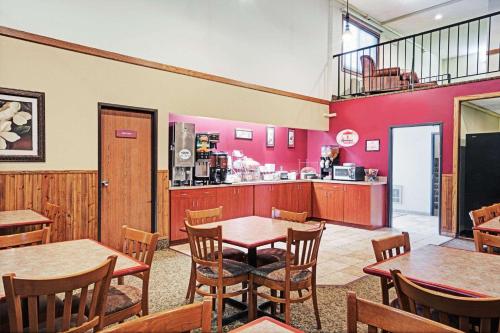 a restaurant with tables and chairs and a counter at Super 8 by Wyndham Rogers Minnesota in Rogers