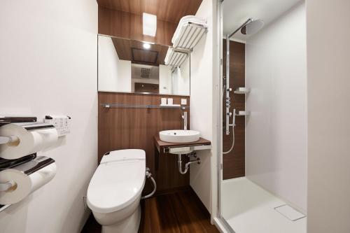 a small bathroom with a toilet and a sink at the b shimbashi toranomon in Tokyo