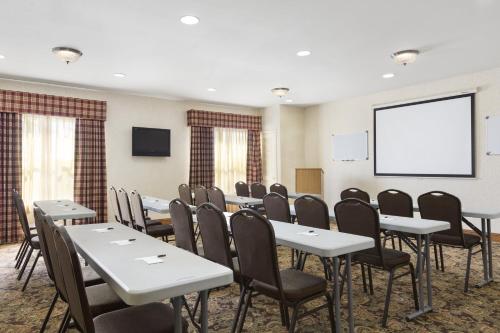 a conference room with tables and chairs and a screen at Country Inn & Suites by Radisson, Smyrna - Atlanta Northwest in Smyrna