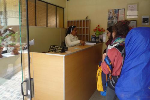 dos mujeres de pie en un mostrador en una sala de espera en Hostal Santa Rosa Cusco, en Cusco