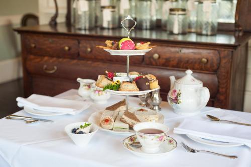 a table with a plate of food and cups of tea at Huntingdon Hotel and Suites in Victoria