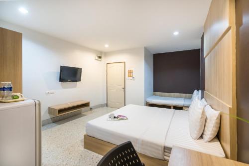 a hotel room with a bed and a tv at The Fifth Residence in Bangkok