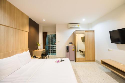 a hotel room with a bed and a tv at The Fifth Residence in Bangkok
