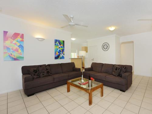 a living room with two couches and a coffee table at Central Plaza Port Douglas in Port Douglas