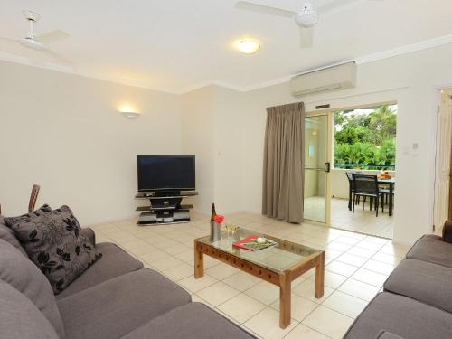 a living room with a couch and a tv at Central Plaza Port Douglas in Port Douglas