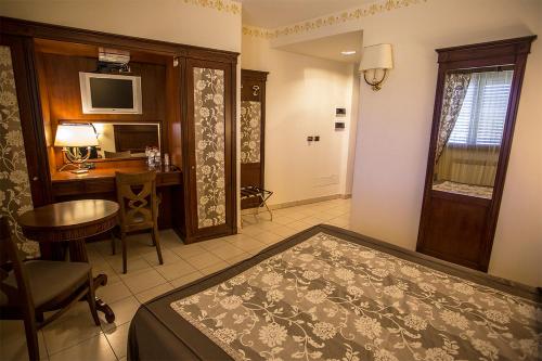 una camera con letto, scrivania e tavolo di Hotel Valeria a Simbario