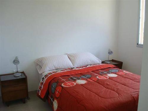 1 cama con edredón rojo en un dormitorio en Ommbungalows en Colón